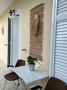 a white table with chairs and a plant on a wall at Lydia’s house in Argostoli