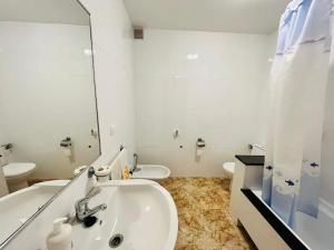 ein Badezimmer mit einem Waschbecken, einer Badewanne und einem WC in der Unterkunft Gran apartamento completo con terraza en O Barqueiro in O Barqueiro