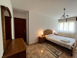 Schlafzimmer mit einem Bett, einer Kommode und einem Spiegel in der Unterkunft Gran apartamento completo con terraza en O Barqueiro in O Barqueiro