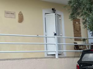 a window on the side of a house with a shutter at Lydia’s house in Argostoli