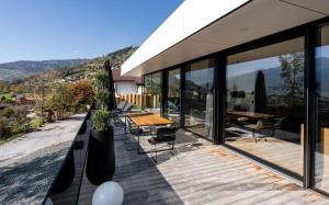 Luxus Design Chalet Sonnrain في بيسندورف: منزل به سطح خشبي مع طاولة وكراسي