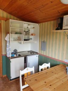 a kitchen with a table and a stove and cabinets at Villaberg in Arvika