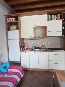 a kitchen with white cabinets and a sink at B&b del bosco e del lago Elimar in Lecco