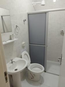 a bathroom with a toilet and a sink and a shower at Residencial Terrazas in Florianópolis +28 photos