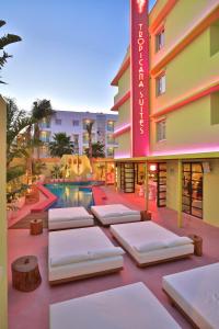 un hotel con letti di fronte alla piscina di Tropicana Ibiza Suites - Adults Only a Playa d'en Bossa