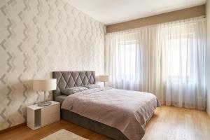 um quarto com uma cama, um candeeiro e uma parede em Alexander apartment em Riga