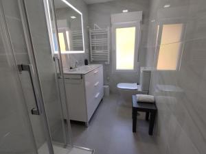 a bathroom with a sink and a toilet and a window at Apartamento Pie de Playa, El Puntal-Villaviciosa in Villaviciosa +26 photos
