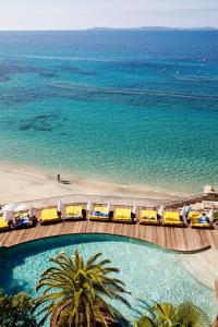 - une vue sur une plage avec plusieurs wagons jaunes dans l'établissement Hôtel Le Bailli De Suffren, à Rayol-Canadel-sur-Mer