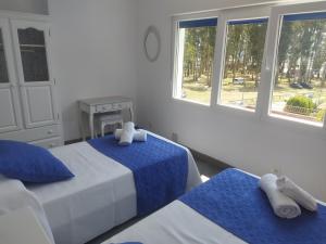 1 dormitorio con 2 camas, sábanas azules y ventanas en Apartamento Pie de Playa, El Puntal-Villaviciosa, en Villaviciosa