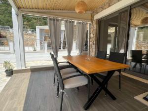 a wooden dining table and chairs on a patio at Lavender Villas Agios Nikitas , Lefkada in Agios Nikitas