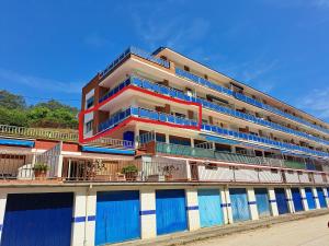 a building with blue doors and balconies on a beach at Apartamento Pie de Playa, El Puntal-Villaviciosa in Villaviciosa