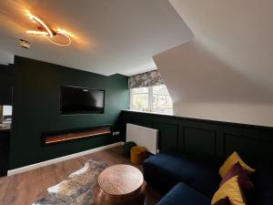 a living room with a green wall with a fireplace at Roslin Templar loft in Roslin