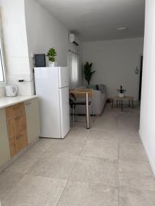 uma cozinha e sala de estar com um frigorífico branco em Good vibes house em Rehovot