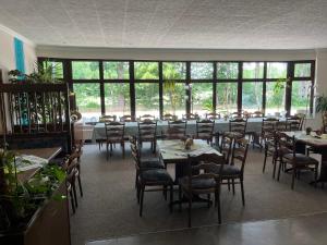 a dining room with tables and chairs and windows at Gästezimmer-Zum Krug im grünen Kranze in Pätower Steegen