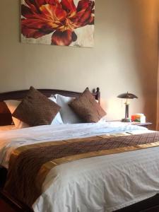 um quarto com uma cama com uma pintura de flores na parede em VILLA ISTANA 9 BEDROOMS em Puncak