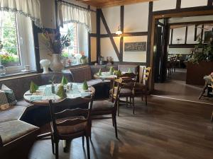 a dining room with tables and chairs in a restaurant at Landhotel & Restaurant Zum Krug im grünen Kranze in Pätower Steegen