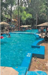 a large swimming pool with people in the water at Departamento con Vista a los cerros con Asador in Yerba Buena