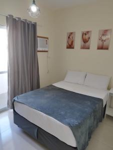 a bedroom with a bed with a blue blanket on it at Residencial Terrazas in Florianópolis