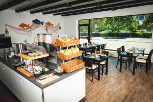 a restaurant with tables and chairs with food on them at Pension am Park in Rust