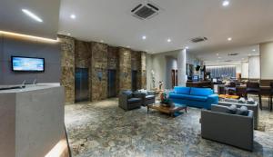 sala de estar con sofás azules y vestíbulo en Plaza Suítes Natal, en Natal