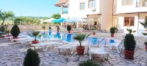 a hotel with a swimming pool with tables and chairs at Апартамент в Oasis Beach Kamchia -THE FAVOURITE BLUE in Bliznatsi