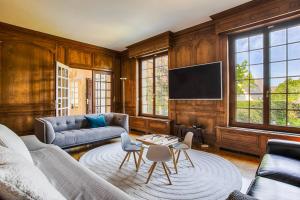 a living room with a couch and a tv at Villa Jorafa - 7 chambres - Jardin - Deauville in Deauville