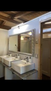 un bagno con due lavandini e un grande specchio di AgriGlamping La Diaccia a Serravalle Pistoiese