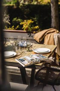 - une table en bois avec des assiettes et des verres à vin dans l'établissement Villa Jorafa - 7 chambres - Jardin - Deauville, à Deauville