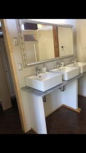 uma casa de banho com 2 lavatórios e um espelho grande em AgriGlamping La Diaccia em Serravalle Pistoiese