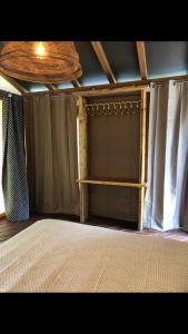a bedroom with a bed and curtains and a ceiling at AgriGlamping La Diaccia in Serravalle Pistoiese