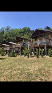 a building with trees in front of a field at AgriGlamping La Diaccia in Serravalle Pistoiese