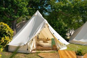 a white tent with a bed in the middle at Kampaoh Ría de Vigo in Moaña