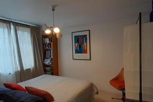 1 dormitorio con 1 cama y 1 silla en Plage et port à 2 min - Appartement ensoleillé, en Dieppe