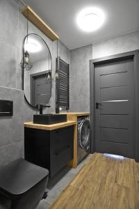 uma casa de banho com um lavatório e uma máquina de lavar roupa em Exclusive Apartments with Private Parking and a Gym na Cracóvia