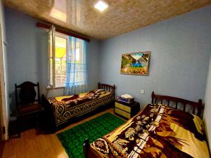 1 dormitorio con 2 camas y ventana en Vaso's Guesthouse, en Katsʼkhi