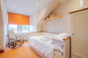 a bedroom with a bed and a chair and a window at Almada Apartment in Hamilton