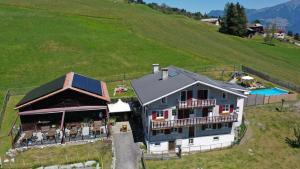 eine Luftansicht eines Hauses auf einem Hügel in der Unterkunft Gasthaus Alpina in Tschappina