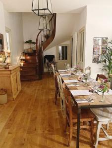 un comedor con una mesa con sillas y una escalera en DIX Restaurant & Chambres d'hotes, en Saint-Alvère