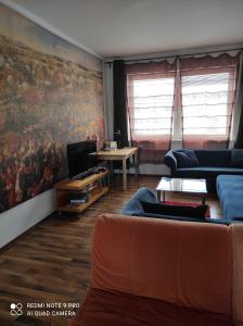a living room with a couch and a painting on the wall at Apartman Maximilian in Bratislava