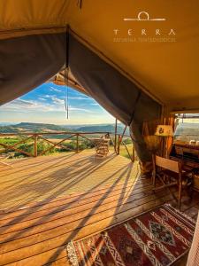 een tent met een terras met uitzicht op de vlaktes bij TERRA - Saturnia tented lodges in Saturnia