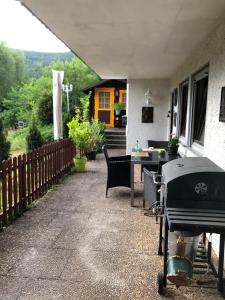 un patio con griglia e tavolo su una casa di Fewo Tannenhof 2 a Kirchzell