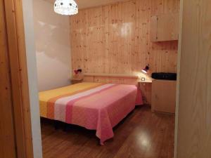 ein Schlafzimmer mit einem Bett mit einer rosa und gelben Decke in der Unterkunft Betulla Bianca Bedollo Ospitar in Bedollo