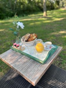 una mesa con una bandeja de pan y un tazón de naranjas en ROULOTTE NATIRAA, en Tarascon