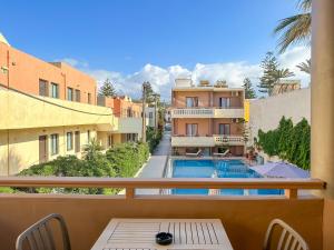 a balcony with a view of a pool and buildings at Ariadne Beach in Platanias