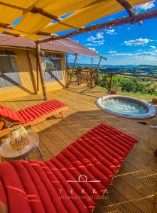 a deck with a hot tub and a red rug at TERRA - Saturnia tented lodges in Saturnia