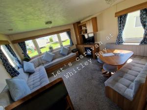a living room with a couch and a table at Let's Caravan at Whitley Bay in Whitley Bay