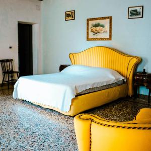sypialnia z żółtym łóżkiem i żółtym krzesłem w obiekcie Villa Trigatti Udine Galleriano 