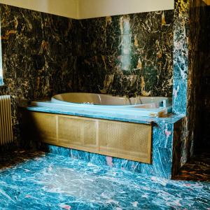 uma banheira na casa de banho com uma parede em mármore em Villa Trigatti Udine Galleriano 