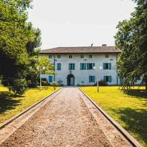 ein großes Gebäude mit einer Schotterstraße davor in der Unterkunft Villa Trigatti Udine Galleriano 
