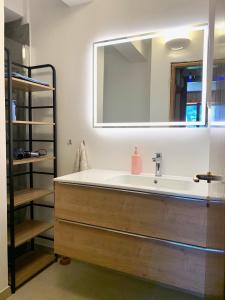 uma casa de banho com um lavatório e um espelho grande em A un passo dagli impianti - Penia di Canazei em Penia